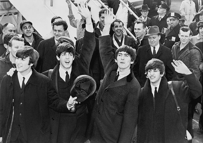 The Beatles wave to fans after arriving at Kennedy Airport. (Photo credit: Wikipedia)